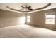 Spacious main bedroom featuring tray ceilings, carpeted floors and natural light from windows at 6114 Pebblebrooke Rd, Whitestown, IN 46075
