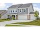 Charming two-story house featuring a three-car garage, complemented by a well-kept lawn and landscaping at 6305 N Woodhaven Dr, McCordsville, IN 46055