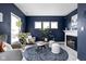 Cozy living room featuring a dark accent wall, bright windows, and modern furniture at 6305 N Woodhaven Dr, McCordsville, IN 46055