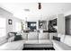 Open-concept living room featuring modern furniture, bright lighting, and seamless flow to dining and kitchen areas at 6305 N Woodhaven Dr, McCordsville, IN 46055
