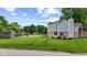 View of backyard featuring sports court, shed, blue/brick exterior, and well-manicured lawn at 6518 Springview Dr, Avon, IN 46123