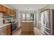 Well-lit kitchen with stainless steel appliances, wooden cabinets and flooring at 6518 Springview Dr, Avon, IN 46123