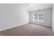 Bright bedroom features neutral carpet, a ceiling fan, and a large window letting in ample natural light at 6963 N Abilene Way, McCordsville, IN 46055