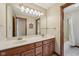 A bathroom featuring double sinks with a wooden vanity and a large mirror with vanity lighting at 6983 White Oak Dr, Avon, IN 46123