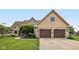 Charming home featuring a two-car garage, brick accents, mature landscaping, and a well-manicured lawn at 6983 White Oak Dr, Avon, IN 46123