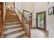 Foyer with stairs to the second floor, wood trim and door, and tiled flooring at 6983 White Oak Dr, Avon, IN 46123