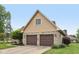 Side view of the two-car garage featuring brick accents and mature landscaping at 6983 White Oak Dr, Avon, IN 46123