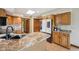 Kitchen island featuring stone counter top, stainless refrigerator and plenty of oak cabinets at 6983 White Oak Dr, Avon, IN 46123
