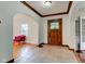 Inviting foyer with a striking wooden front door, complemented by classic archways and tiled flooring at 715 Kessler Blvd E Dr, Indianapolis, IN 46220