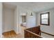Bright hallway featuring hardwood floors and view into bedroom with a built-in bookshelf at 715 Kessler Blvd E Dr, Indianapolis, IN 46220