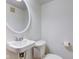 Clean powder room with a pedestal sink, round mirror, and toilet at 715 Kessler Blvd E Dr, Indianapolis, IN 46220