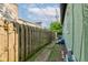 Narrow side yard with a concrete walkway, wooden fence, and view of the home's exterior at 715 Kessler Blvd E Dr, Indianapolis, IN 46220