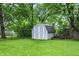 Fenced in backyard with green grass and a gray shed near mature trees at 7430 Railway Ct, Indianapolis, IN 46256