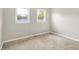 A neutral bedroom with carpet and bright natural light from the two windows at 7430 Railway Ct, Indianapolis, IN 46256