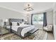 Bedroom features neutral tones, a tufted headboard, window, and geometric chandelier at 7430 Railway Ct, Indianapolis, IN 46256