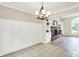 Dining room showing tile flooring, wainscotting, a chandelier and entry into the living room with a brick fireplace at 7430 Railway Ct, Indianapolis, IN 46256