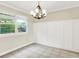 Bright dining room with modern chandelier, neutral paint, board and batten trim and large window at 7430 Railway Ct, Indianapolis, IN 46256