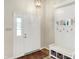 Bright foyer boasts a white door, coat rack and bench with basket storage and a decorative light fixture at 7430 Railway Ct, Indianapolis, IN 46256