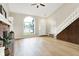 Open living area features hardwood floors, a vaulted ceiling, brick fireplace and a large window for natural light at 7430 Railway Ct, Indianapolis, IN 46256