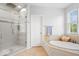 Bright bathroom features a soaking tub, glass-enclosed shower, and a window with natural light at 745 Ridge Gate Dr, Brownsburg, IN 46112
