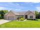 Charming brick ranch home boasts an attached three-car garage and a verdant front yard at 745 Ridge Gate Dr, Brownsburg, IN 46112