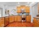 A well-equipped kitchen featuring wood cabinetry, granite counters, and stainless steel appliances at 745 Ridge Gate Dr, Brownsburg, IN 46112