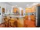 Eat-in kitchen featuring hardwood floors, center island with seating, and stainless steel appliances at 745 Ridge Gate Dr, Brownsburg, IN 46112