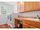 Bright laundry room with hardwood floors, wooden cabinets and a utility sink, providing ample space for laundry tasks at 745 Ridge Gate Dr, Brownsburg, IN 46112