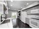 Kitchen featuring light grey cabinets, hardwood floors, stainless steel appliances, and a view of the backyard at 7507 Choate Ct, Indianapolis, IN 46254