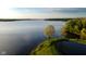 Aerial view of a lake featuring lush greenery and clear blue water at 7507 Choate Ct, Indianapolis, IN 46254