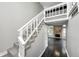 Bright staircase with a white railing, leading to a stone fireplace, and dark hardwood floors at 7507 Choate Ct, Indianapolis, IN 46254