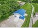 Aerial view of a modern garage with a blue metal roof and a gravel yard surrounded by green lawns at 7850 S Mooresville Rd, Indianapolis, IN 46113