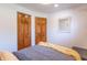Cozy bedroom featuring two wooden doors, and a neatly arranged bed with grey sheets and yellow throw at 7850 S Mooresville Rd, Indianapolis, IN 46113