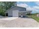 Well-maintained building with a garage door, side door, and carport on a gravel lot at 7850 S Mooresville Rd, Indianapolis, IN 46113