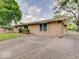 Side view of the brick home with a spacious driveway and lush greenery surrounding the property at 8071 Chiltern Dr, Indianapolis, IN 46268