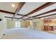 Open living room with exposed wood beams, large windows, and a view into the kitchen at 8071 Chiltern Dr, Indianapolis, IN 46268