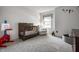 Well-lit Bedroom with neutral carpet, modern crib, an accent chair and a variety of toys at 8223 Thoroughbred Run, Indianapolis, IN 46256