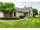 Charming home with a well-manicured lawn, mature trees, and inviting brick accents enhancing its curb appeal at 8223 Thoroughbred Run, Indianapolis, IN 46256
