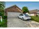 Brick home featuring an attached two-car garage and a driveway with a parked car at 8223 Thoroughbred Run, Indianapolis, IN 46256