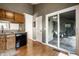 Well-lit kitchen with granite countertops, black appliances, hardwood floors and access to a screened-in porch at 8223 Thoroughbred Run, Indianapolis, IN 46256