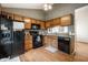 Functional kitchen with wood cabinets, modern black appliances, and efficient layout and design at 8223 Thoroughbred Run, Indianapolis, IN 46256