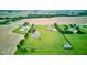 Aerial perspective of a large property with a pond and outbuildings, featuring green space and an inviting home at 8371 N 400 W, Fairland, IN 46126