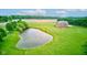 Aerial view of a pond near a brick home with a lush green lawn, offering privacy and a scenic view at 8371 N 400 W, Fairland, IN 46126