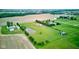 Overhead view of a large property featuring a brick house, pond, outbuildings, and surrounding green space, showcasing privacy at 8371 N 400 W, Fairland, IN 46126