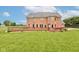 Expansive backyard showcasing a brick home with a large wooden deck, well-kept lawn and manicured shrubbery at 8371 N 400 W, Fairland, IN 46126