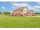 Spacious backyard view featuring a brick house with a deck, a large grass area, and a well-maintained lawn at 8371 N 400 W, Fairland, IN 46126