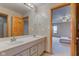 Bathroom with a large mirror, double sinks, tile flooring, and an open doorway to the Primary bedroom at 8371 N 400 W, Fairland, IN 46126