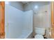 Bathroom with a white shower and bath, a toilet, tile flooring and a wood door at 8371 N 400 W, Fairland, IN 46126