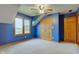 Well-lit bedroom with bright blue walls, carpet, a ceiling fan, and a closet for storing all of your clothing at 8371 N 400 W, Fairland, IN 46126