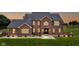 Elegant brick home with warm interior lights glowing, set against a twilight sky and lush green lawn at 8371 N 400 W, Fairland, IN 46126